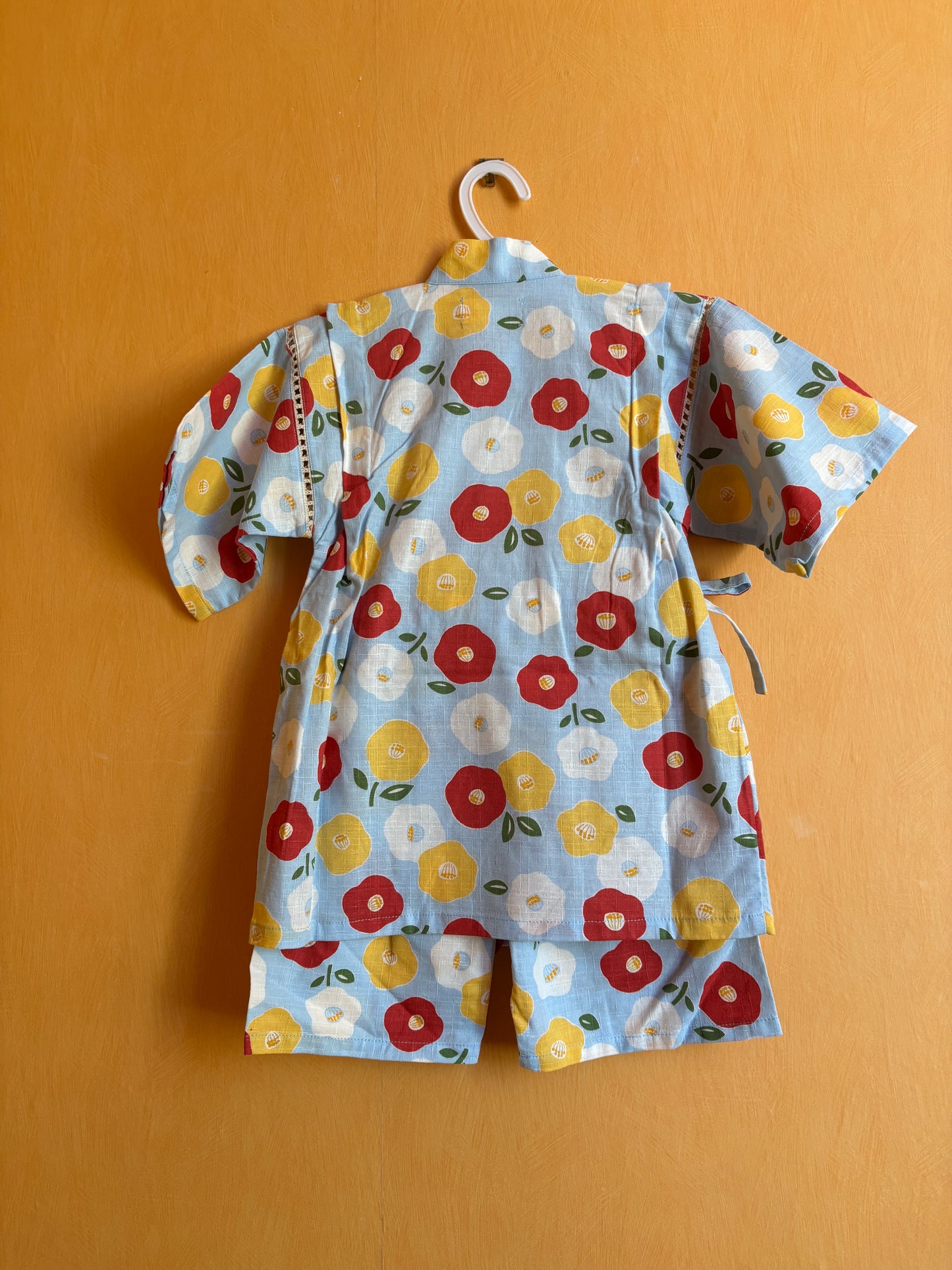 jinbei façon pyjamas, motifs floraux rouge, jaune et blanc sur fond bleu clair, fille